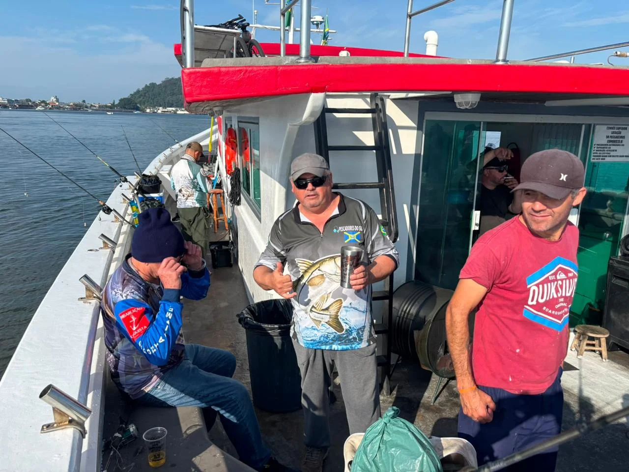 Pescadores reunidos na embarcação com suas capturas